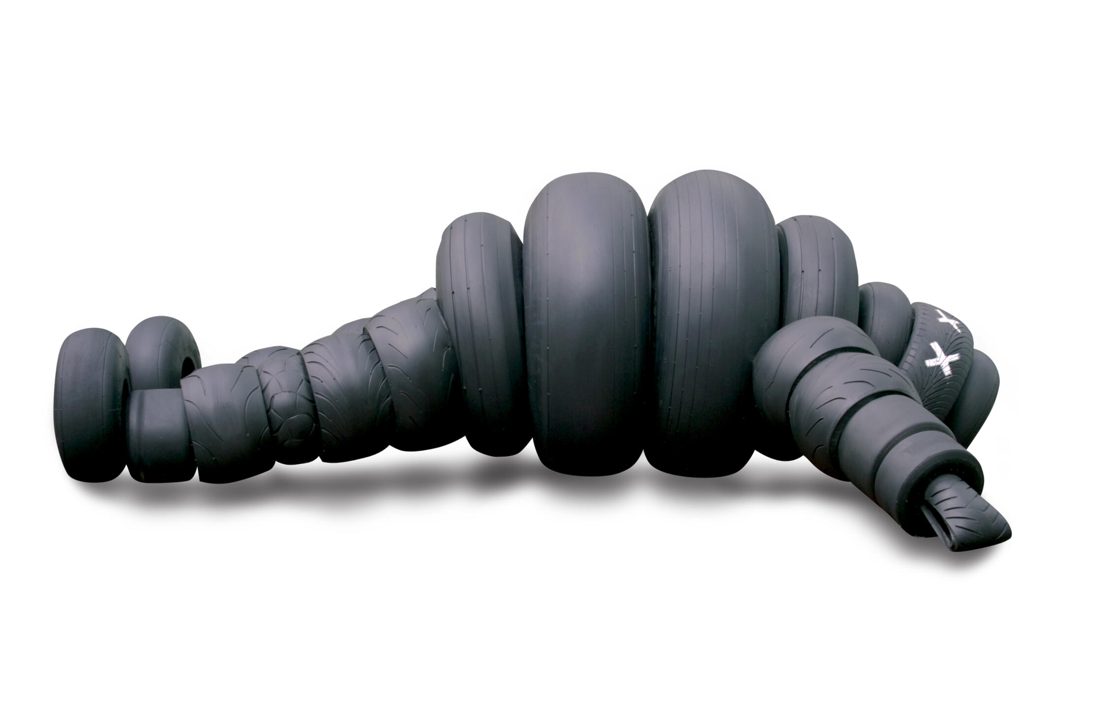 Black sculptural form resembling stacked tires on a white background.