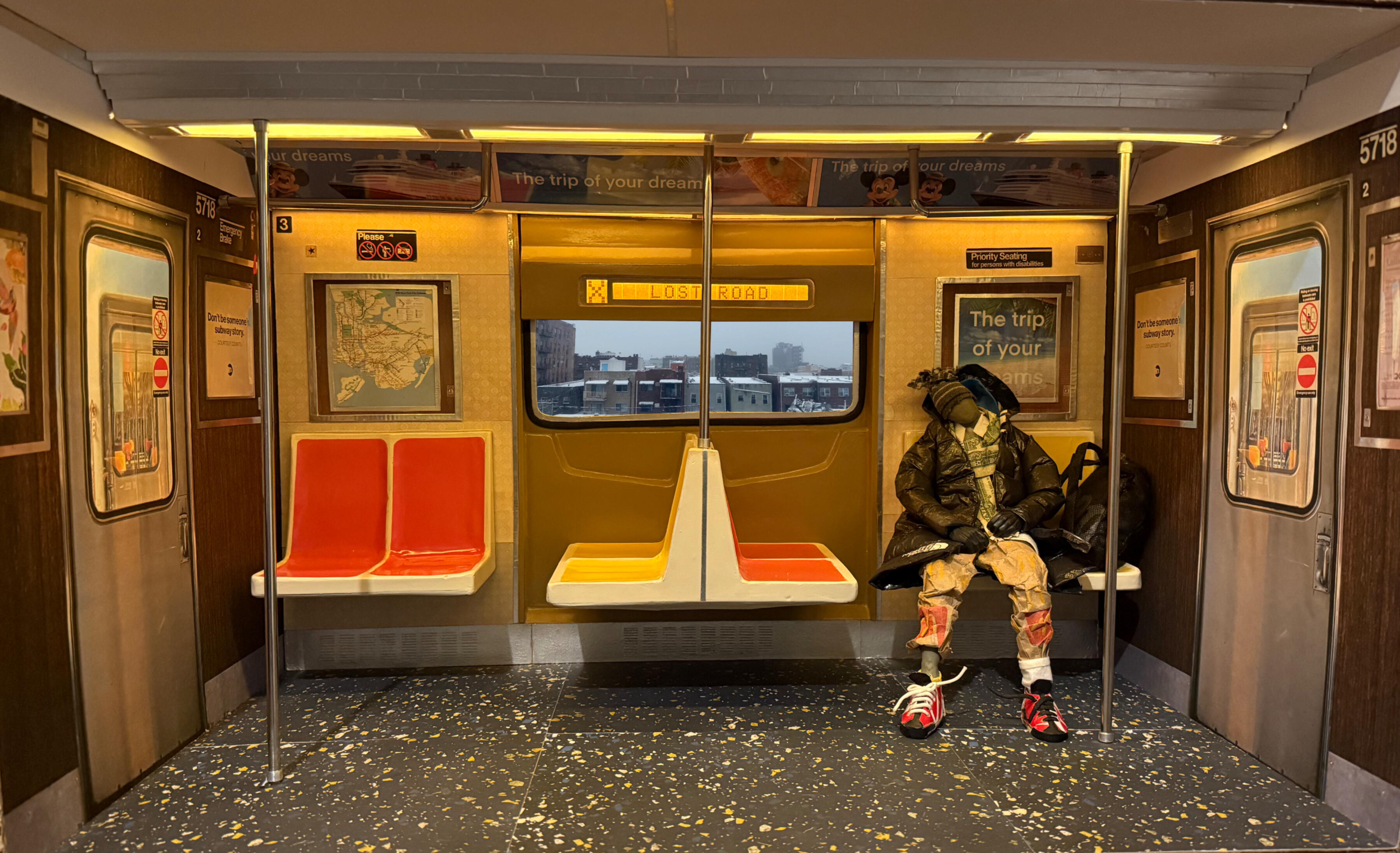 Black sculptural form resembling stacked tires on a white background.
