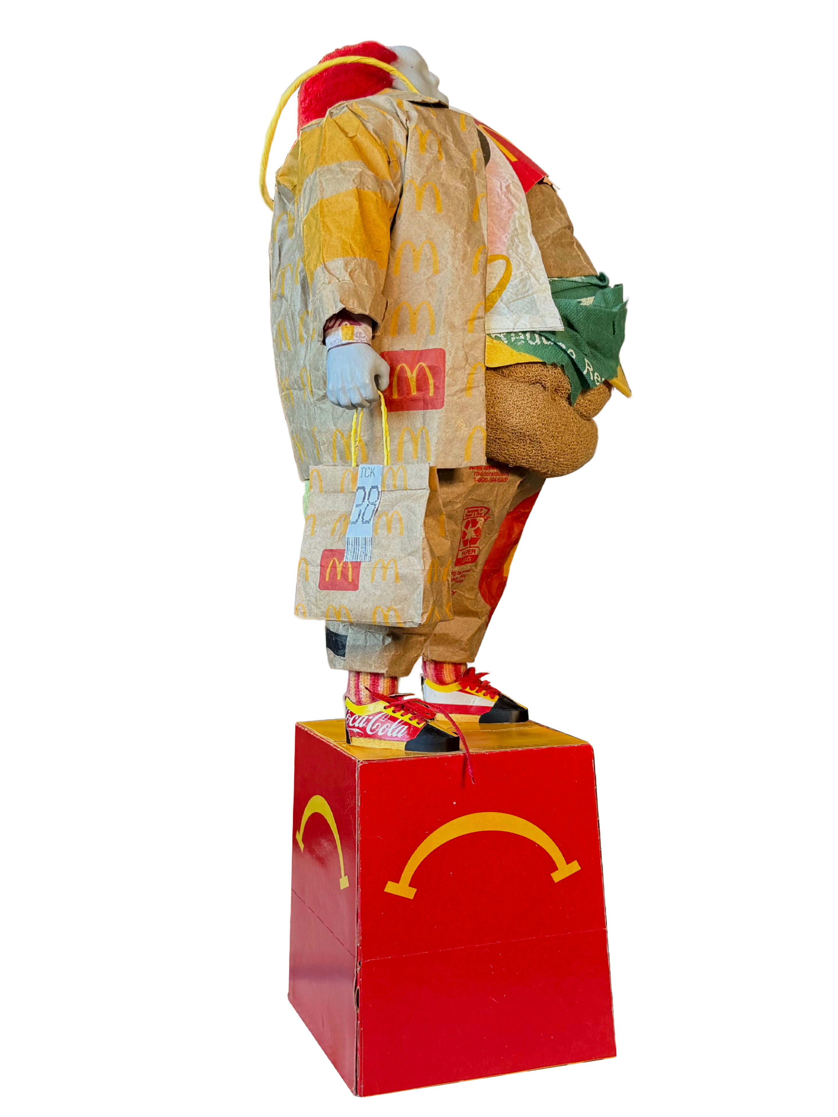 Black sculptural form resembling stacked tires on a white background.