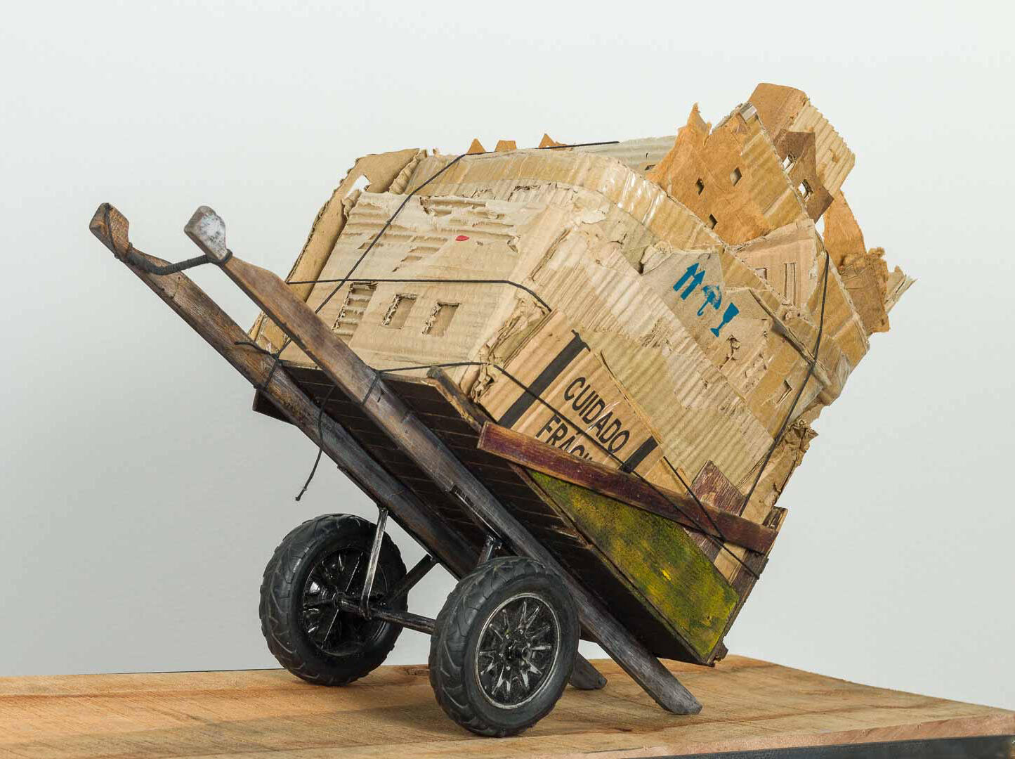 Black sculptural form resembling stacked tires on a white background.