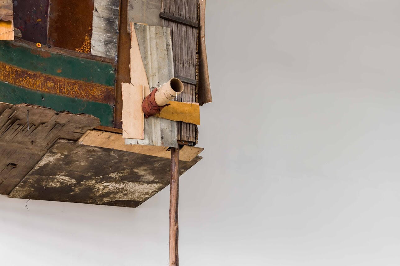 Black sculptural form resembling stacked tires on a white background.