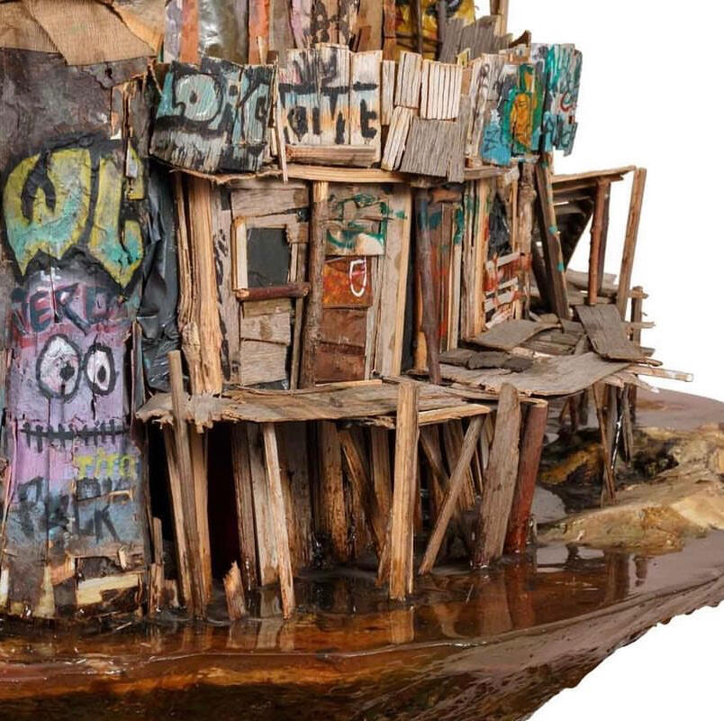 Black sculptural form resembling stacked tires on a white background.