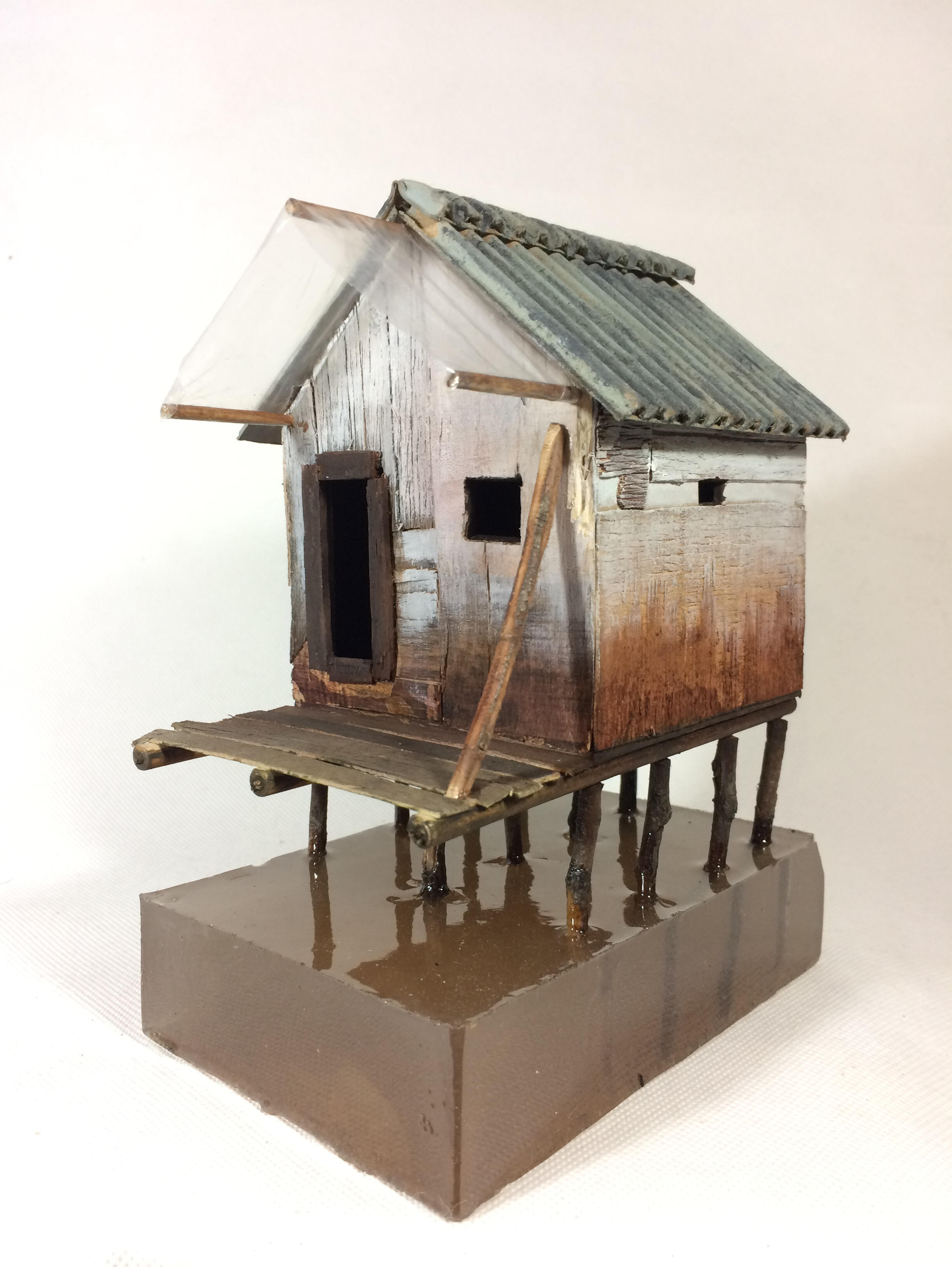 Black sculptural form resembling stacked tires on a white background.