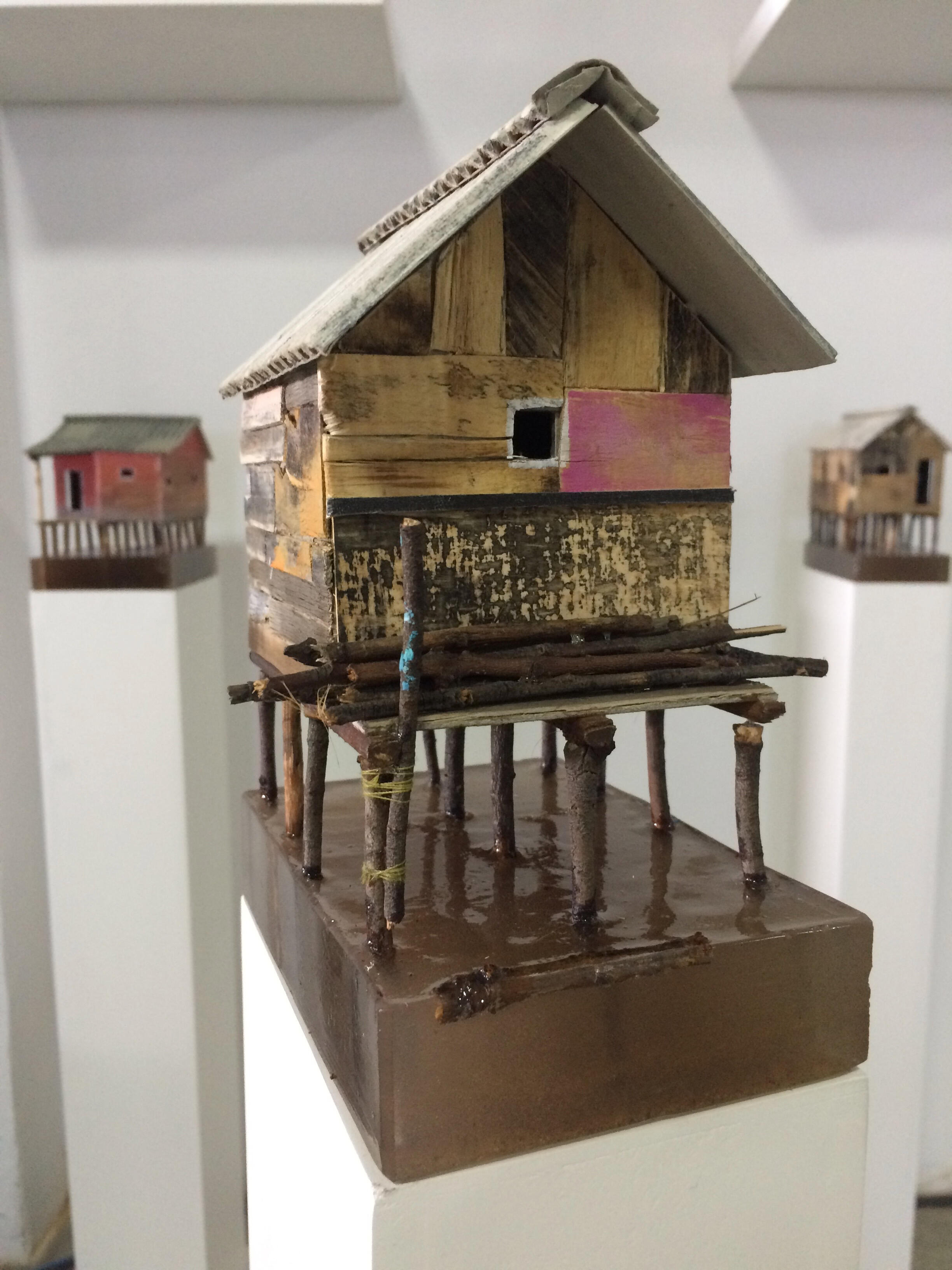 Black sculptural form resembling stacked tires on a white background.